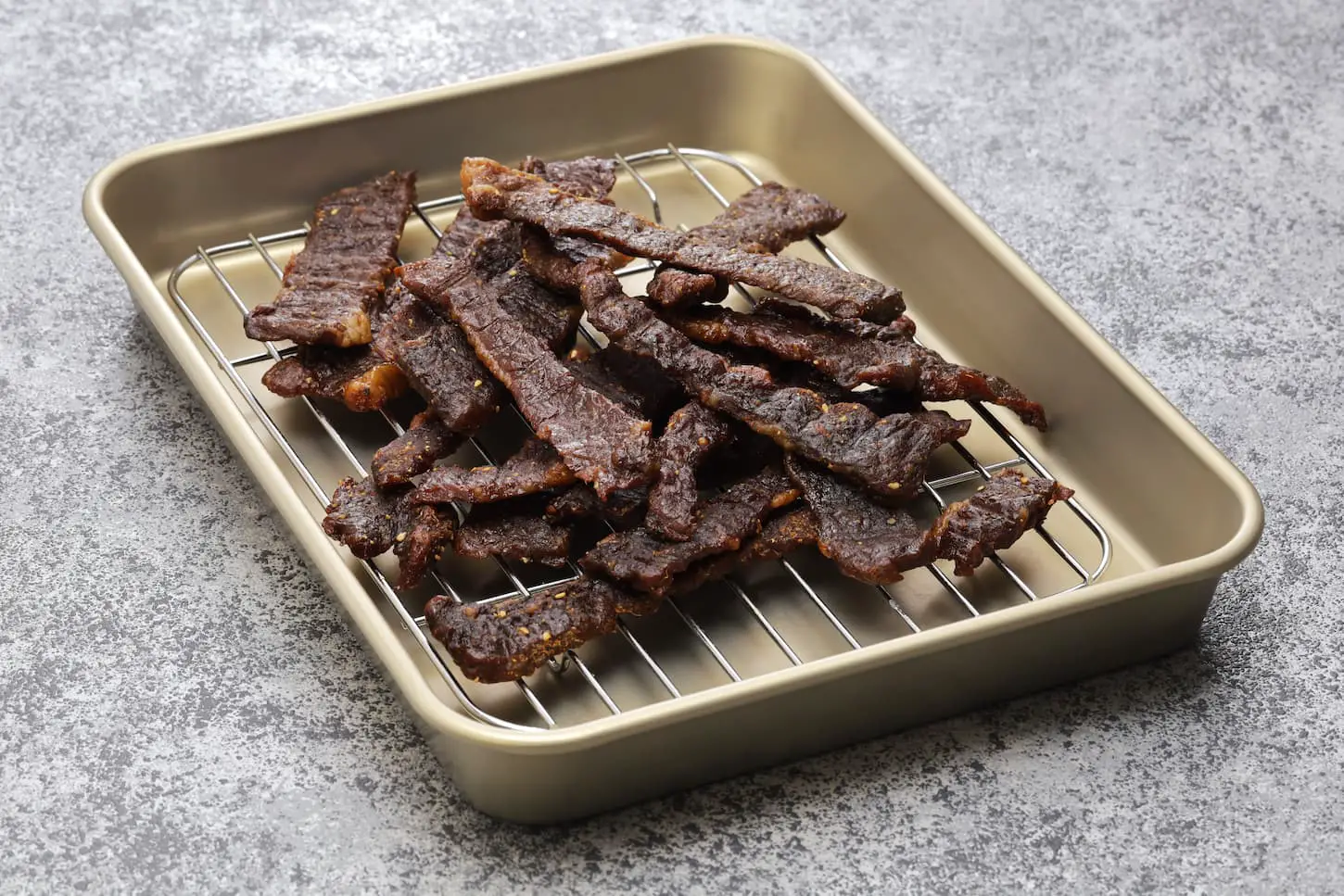 An image of dried homemade beef jerky on a tray.