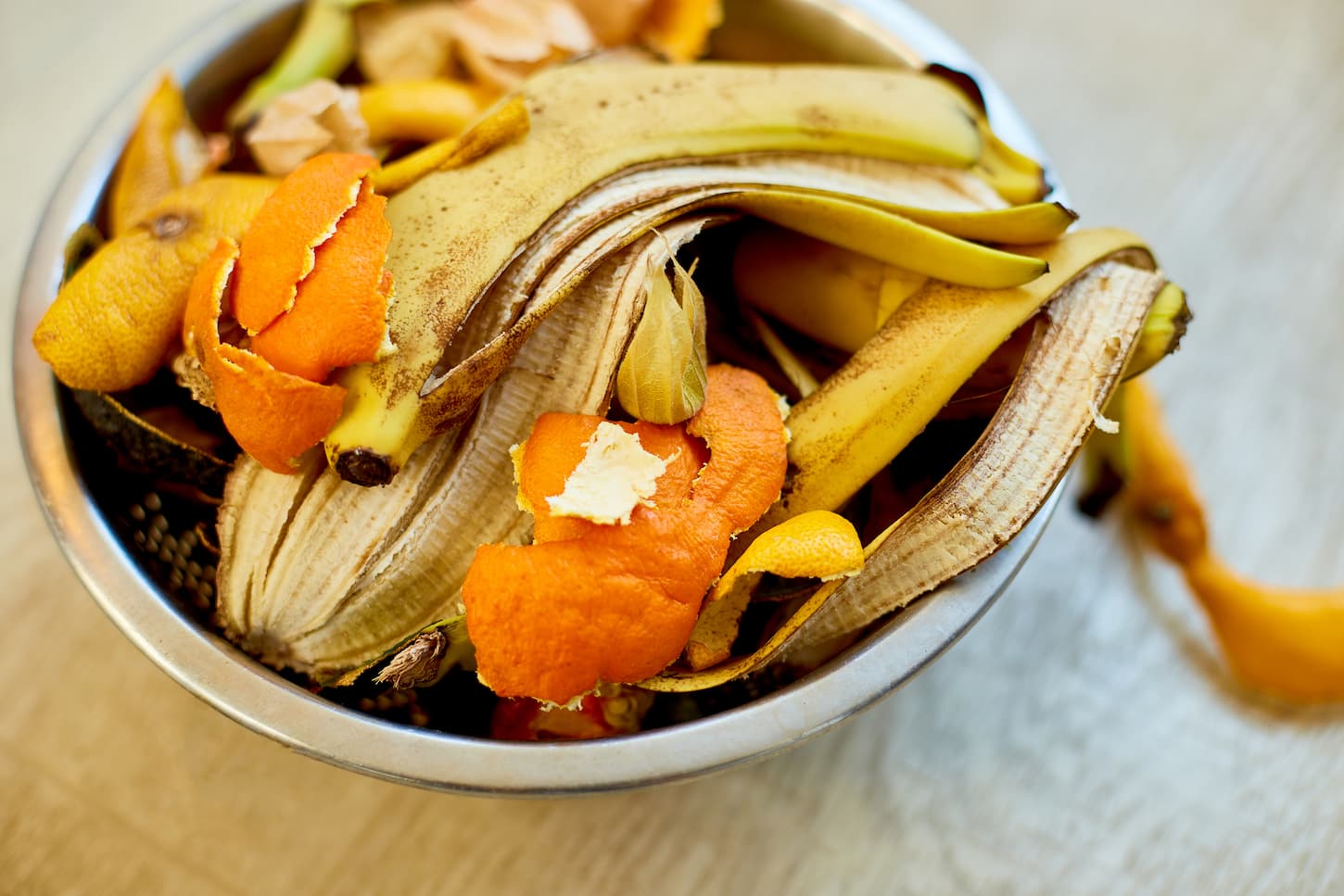 An image of banana peel and orange peel leftover in a bowl as organic compost.