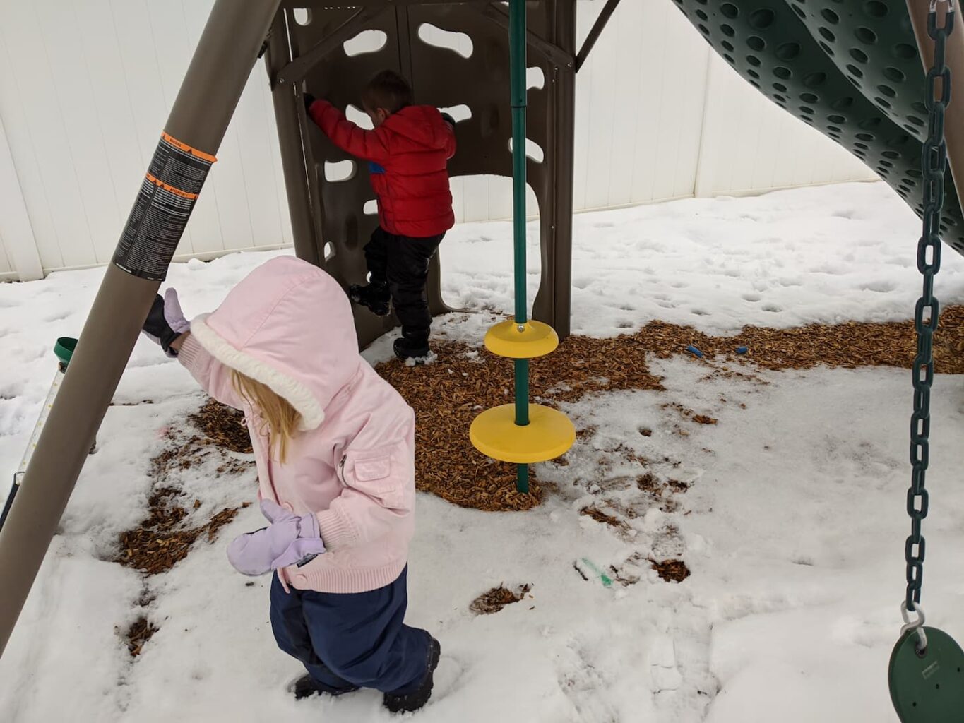 An image of my kids getting ready to go check eggs in the winter with a layer of snow on the ground.