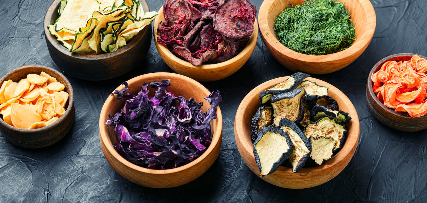 An image of dried carrots, cabbage, garlic, herbs, and zucchini.