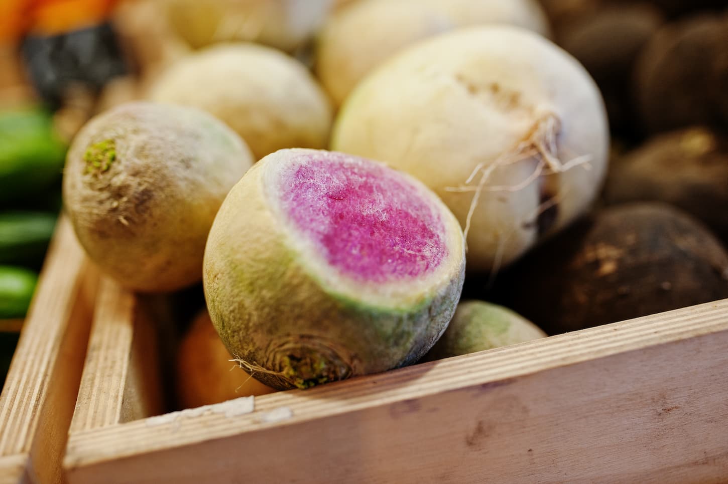 An image of colorful, shiny, and fresh turnips on the shelf of a supermarket or grocery store.