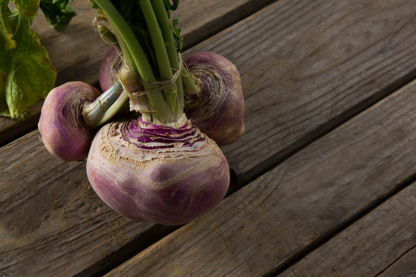 An image of bundled turnips on a wooden table.