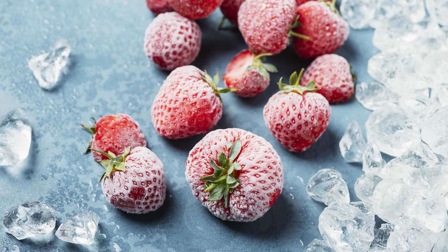An image of frozen strawberries with crystals of ice.
