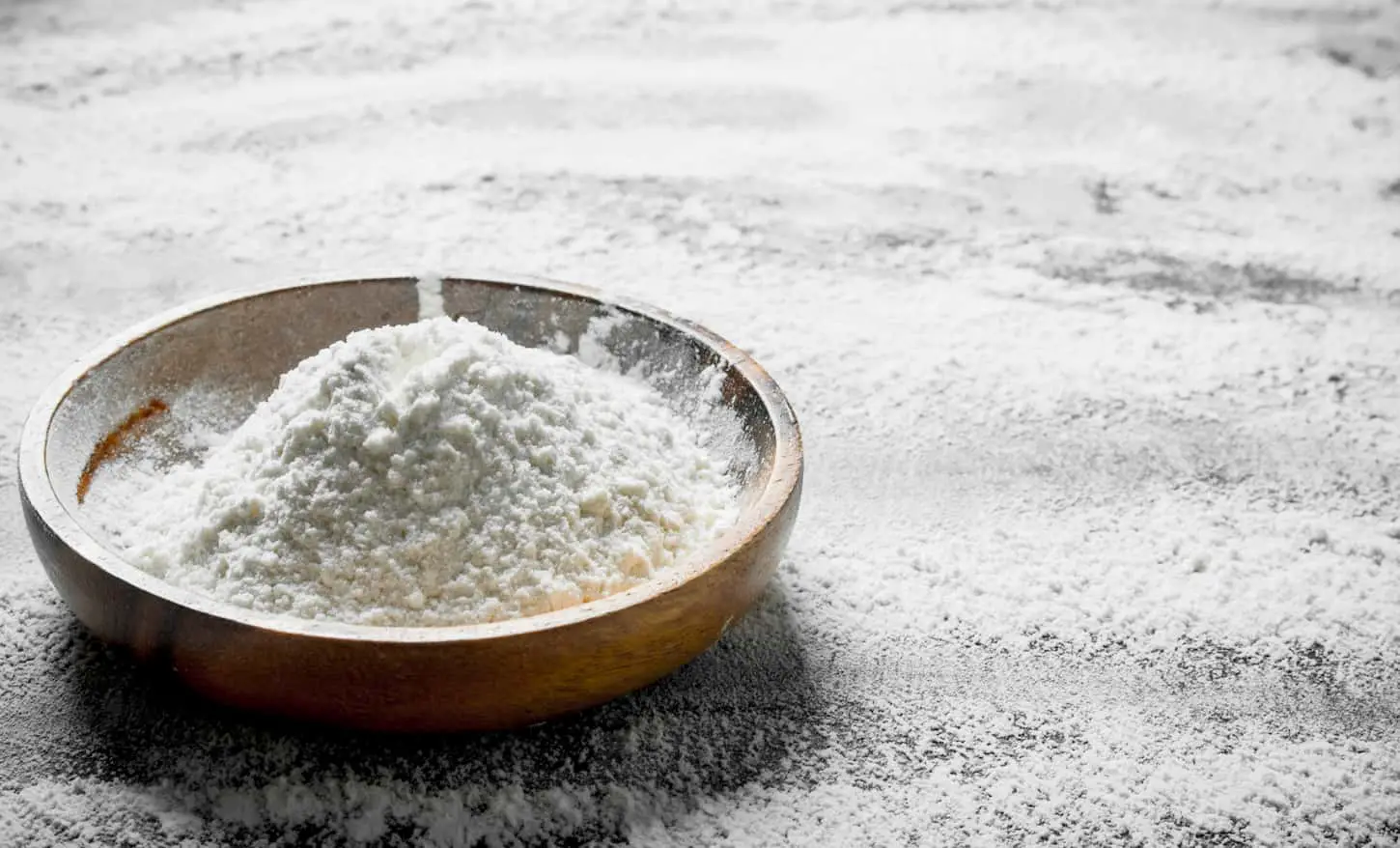 An image of Flour on a plate on a rustic background.