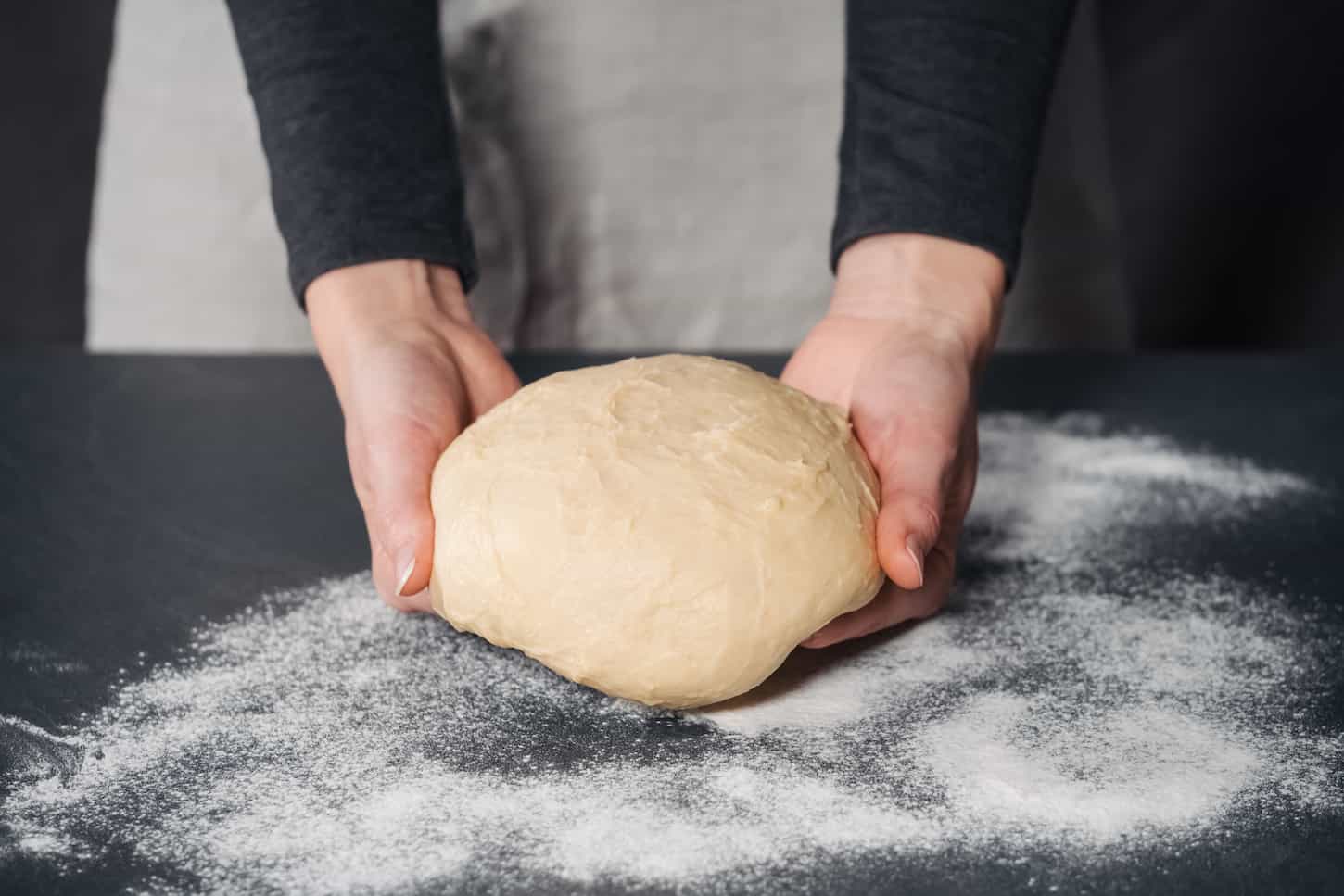 An image of a Woman making handmade dough for bread.