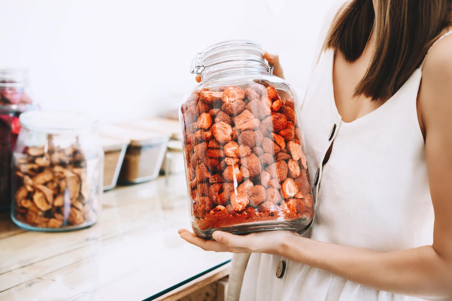 An image of a Woman buying dried fruits and berries in a plastic-free store.